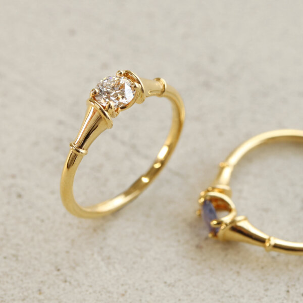 Drawing inspiration from the sleek forms of glasses and trumpets, this design was born from a desire to create curves that move gracefully with the wearer. Its clean, flowing lines are accented by playful touches, while the diamonds catch the light to shine with striking brilliance.