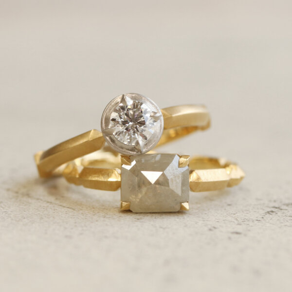 A truly unique engagement ring, radiating a presence all its own. Its band, adorned with a sequence of geometric patterns, is subtly accented with diamonds, while the hand-finished matte texture beautifully enhances the brilliance of your chosen stone.